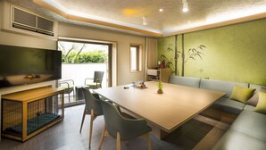 A modern living room with a large flat-screen TV, a wooden coffee table, a sofa, and a dining table with chairs. - Hakone Pet-friendly Inn Yuniwa (Hakone)
