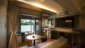 A modern living room with a sofa, a round table, a TV, and a large window. - Hakone Pet-friendly Inn Yuniwa (Hakone)