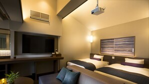 A hotel room with a TV, two beds, a sofa, a small table with a plant, and a ceiling projector. - Hakone Pet-friendly Inn Yuniwa (Hakone)