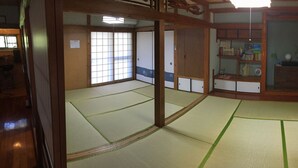 Une pièce de style japonais traditionnel, avec un sol recouvert de tatamis, des portes coulissantes et une bibliothèque.