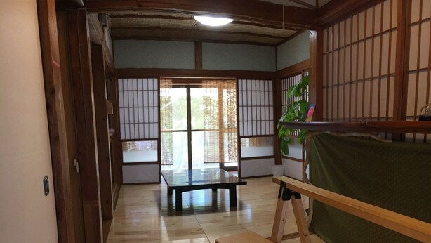 Une pièce de style japonais traditionnel, avec un sol recouvert de tatamis, une table basse, un banc et des paravents en papier de riz (shoji).