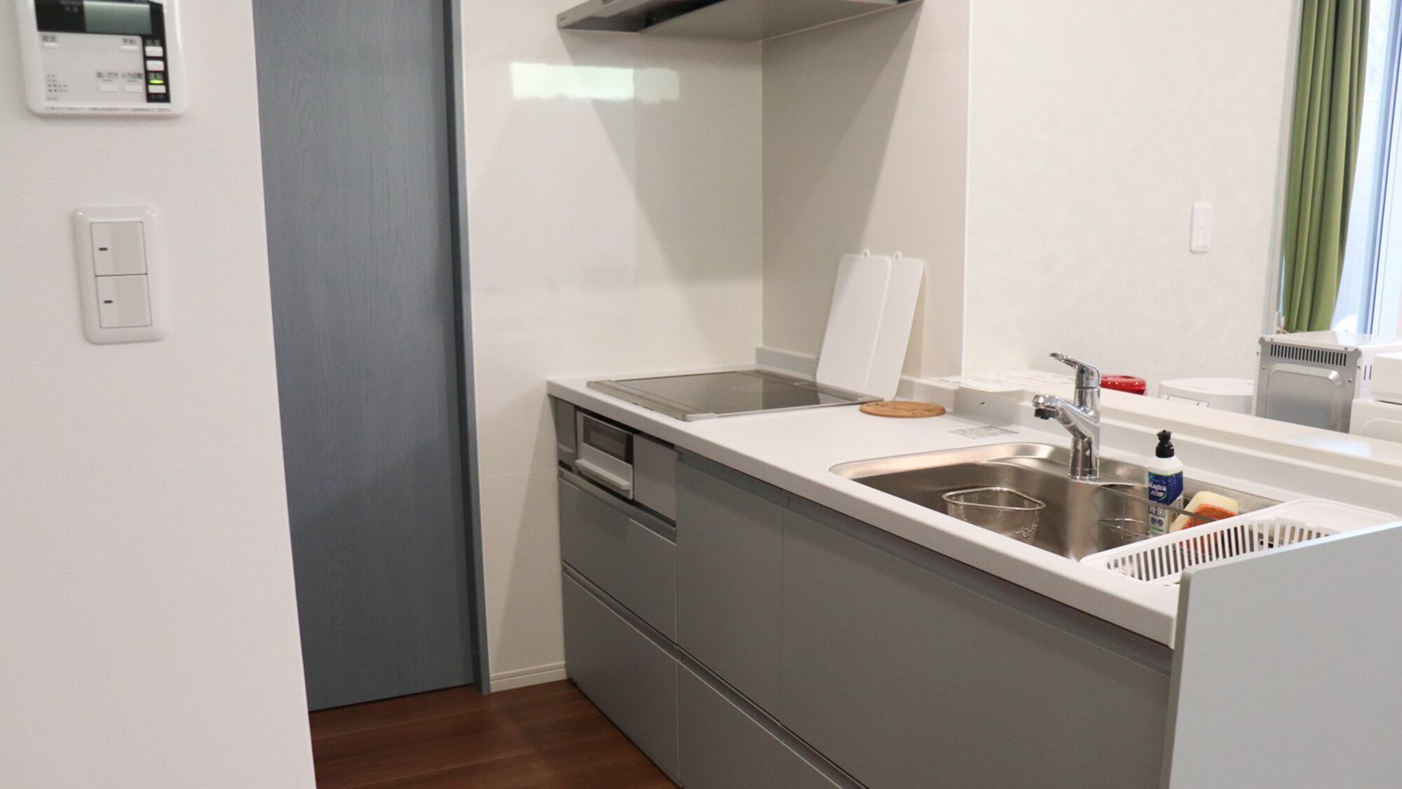 Une petite cuisine équipée comprenant une cuisinière intégrée, un évier et des tiroirs de rangement.