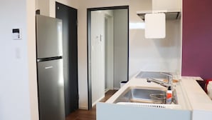 A modern kitchen with a stainless steel refrigerator, a sink, and a white countertop. - Chokotto Villa Maestro (Sumoto)
