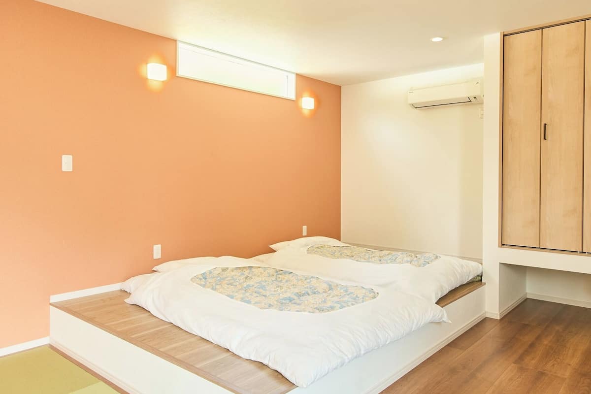 Ein Schlafzimmer mit zwei Betten, einer Klimaanlage und einem Kleiderschrank.