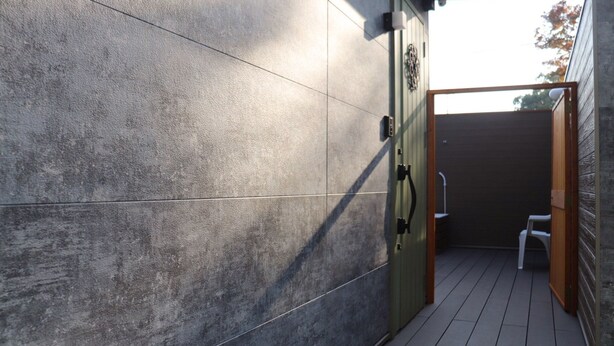 A modern outdoor area with a wooden deck, a metal gate, and a small white chair. - Chokotto Villa Maestro (Sumoto)