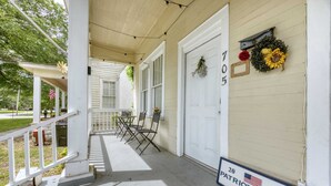 A porch with a white railing, a table, and chairs. There is a door with the number 705 and a sign that says "Patriot Family Homes". - Near Chattahoochee River & Shops - Central Duplex (Columbus)