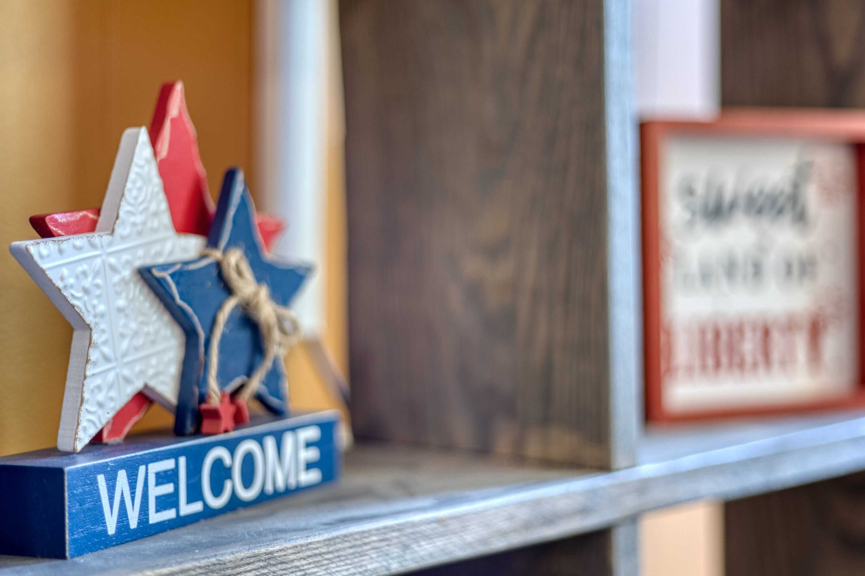 Ein Willkommensschild mit Sternenverzierung und einem 'WELCOME'-Schild auf einem Regal.