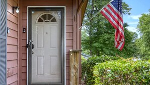 A house with a front door, a chimney, and an American flag.