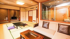 A traditional Japanese-style room with tatami flooring, a tatami mat table, a sofa, and a sliding door. - Okunikko Yumoto Onsen Okunikko Kogen Hotel (Nikko)