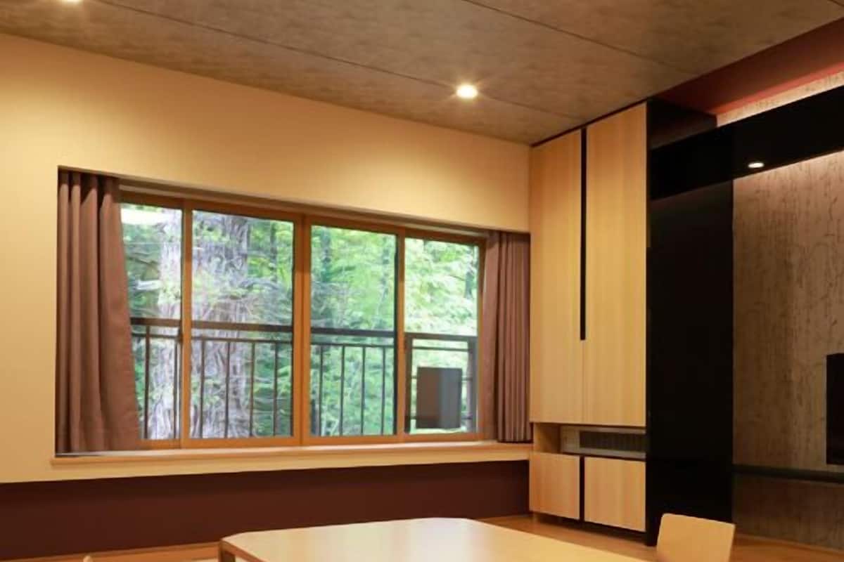 Ein modernes Interieur mit einem großen Fenster, einem Esstisch und einer Küchenzeile.