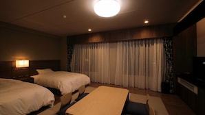 A hotel room with two beds, a small table, a TV, and a curtain backdrop. - Okunikko Yumoto Onsen Okunikko Kogen Hotel (Nikko)