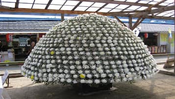 A large spherical floral arrangement in an outdoor setting with a covered structure overhead.
