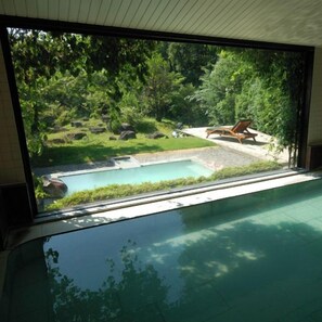 A room with a large window overlooking a swimming pool and a garden. - Dake Onsen Soranoniwa Resort (Nihommatsu)