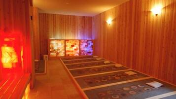 A sauna room with wooden walls and a floor with circular patterns.
