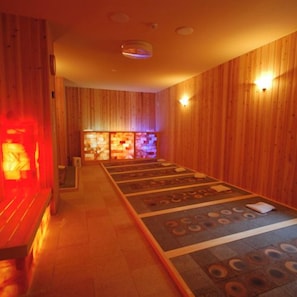 Una sala de sauna con paredes de madera y un suelo con diseños circulares.