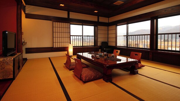 Ein traditioneller japanischer Raum mit Tatami-Boden, einem niedrigen Tisch und Schiebetüren.