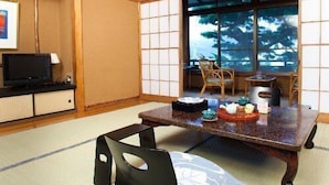 A traditional Japanese room with tatami flooring, a low table with tea set, and sliding doors. - Izunagaoka Onsen Ebisuya (Izunokuni)