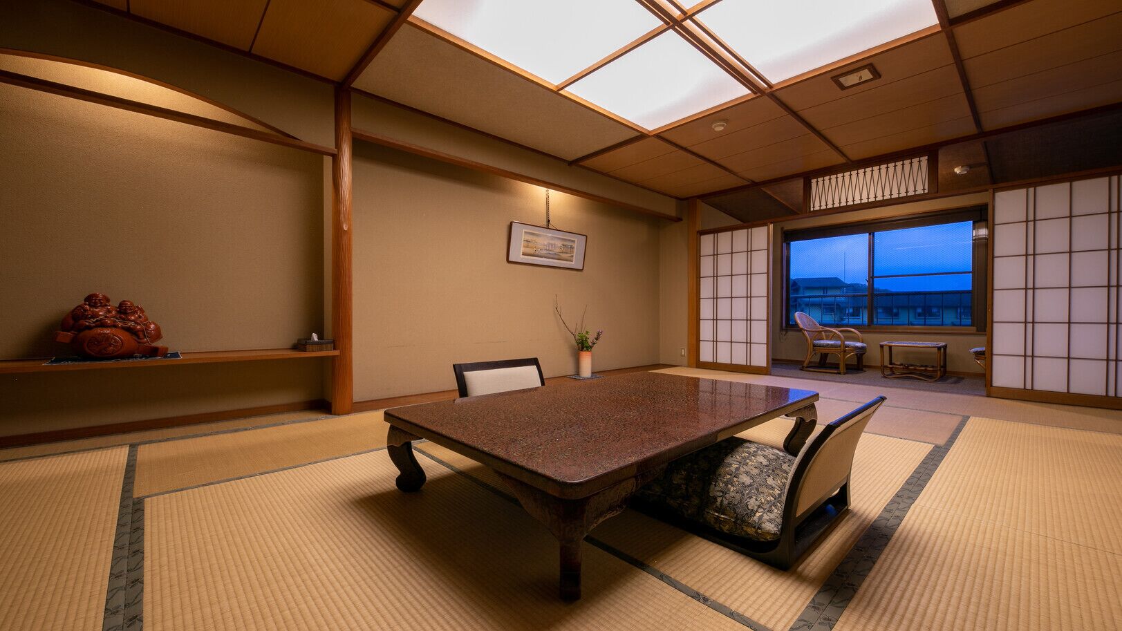 Ein traditioneller japanischer Raum mit Tatami-Böden, einem niedrigen Tisch und verschiebbaren Türen.