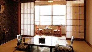 A traditional Japanese room with tatami flooring, a low table, and shoji screens. - Izunagaoka Onsen Ebisuya (Izunokuni)
