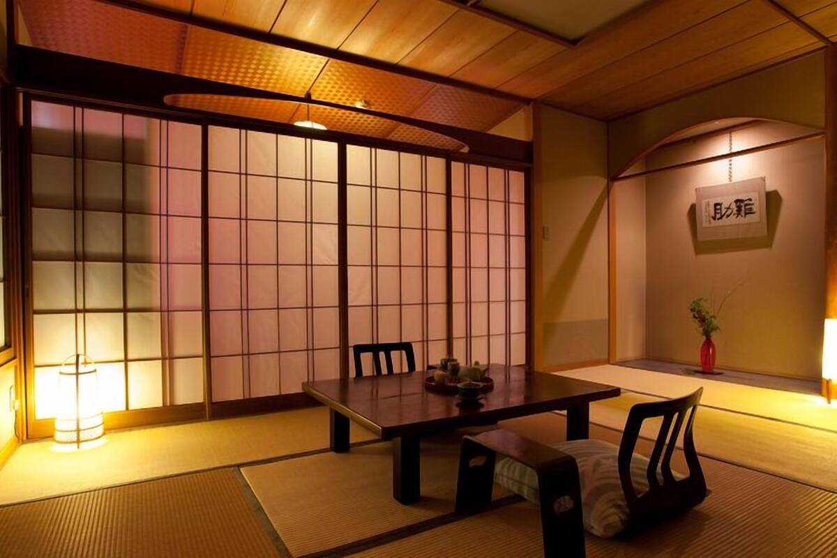 A traditional Japanese room with tatami flooring, a low table, and shoji screens.