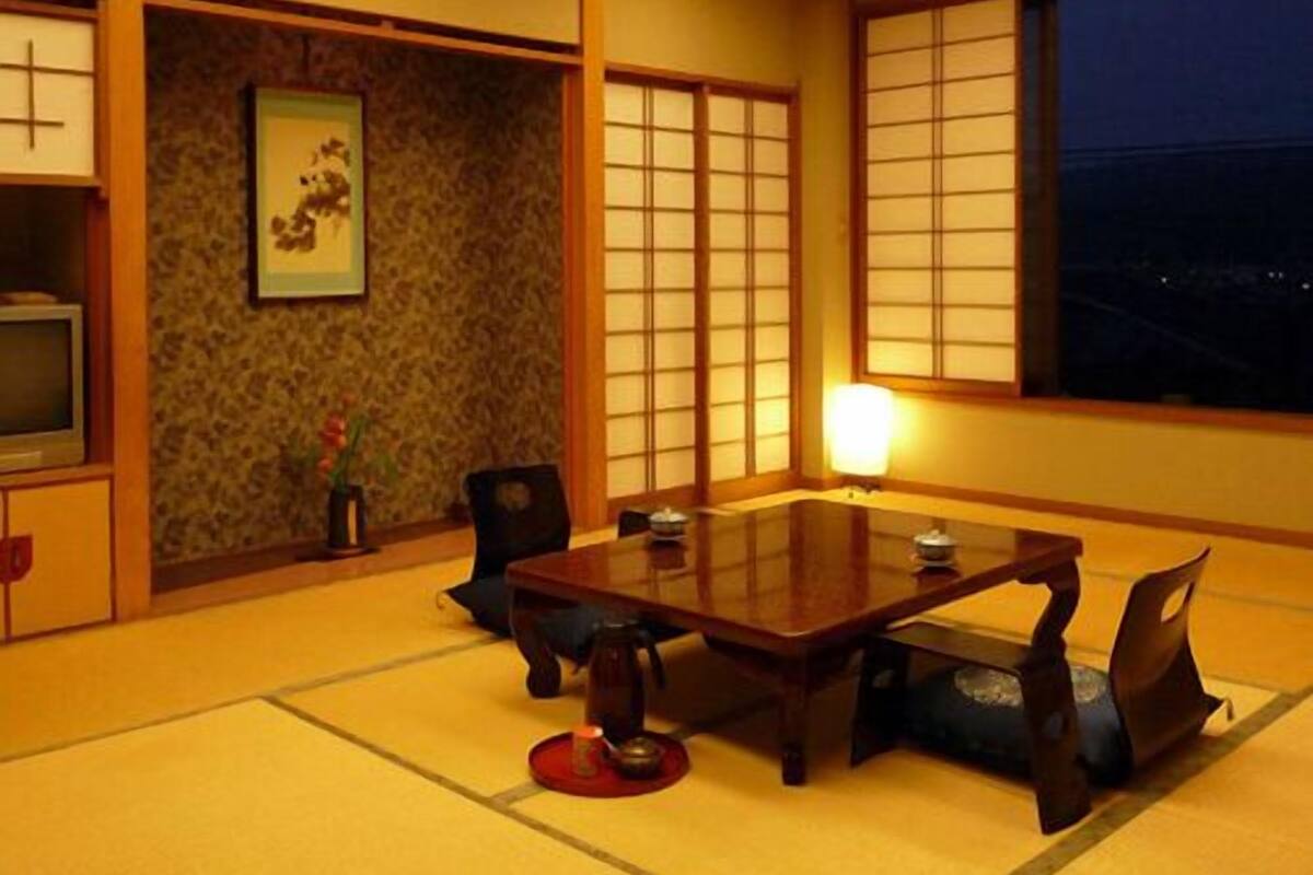 A traditional Japanese room with tatami flooring, a low table, and shoji screens.