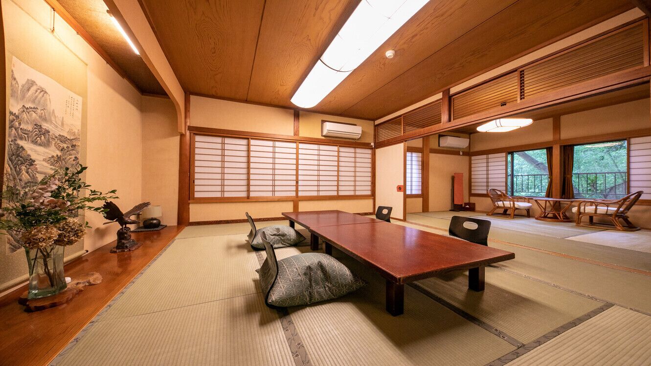 Ein traditioneller japanischer Raum mit Tatami-Böden, einem Holztisch, Tatami-Matten, einem Shoji-Bildschirm und Blick ins Freie.