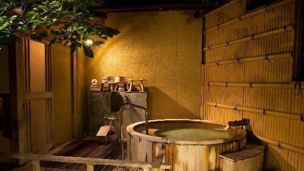 A traditional Japanese onsen with a wooden bath, stone steps, and a lantern. - Izunagaoka Onsen Ebisuya (Izunokuni)