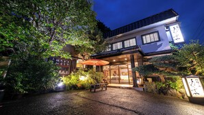 A traditional Japanese building with a covered entrance, a stone lantern, and a wooden bench in the courtyard. - Izunagaoka Onsen Ebisuya (Izunokuni)