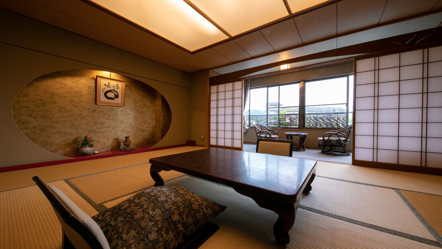Ein traditioneller japanischer Raum mit Tatami-Böden, einem niedrigen Tisch und Blick durch Shoji-Schirme.