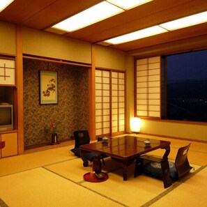 A traditional Japanese room with tatami flooring, a low table, and shoji screens.