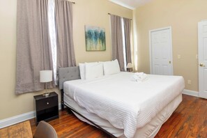 Una habitación de hotel con una cama grande, una mesita de noche, una lámpara y un cuadro en la pared.