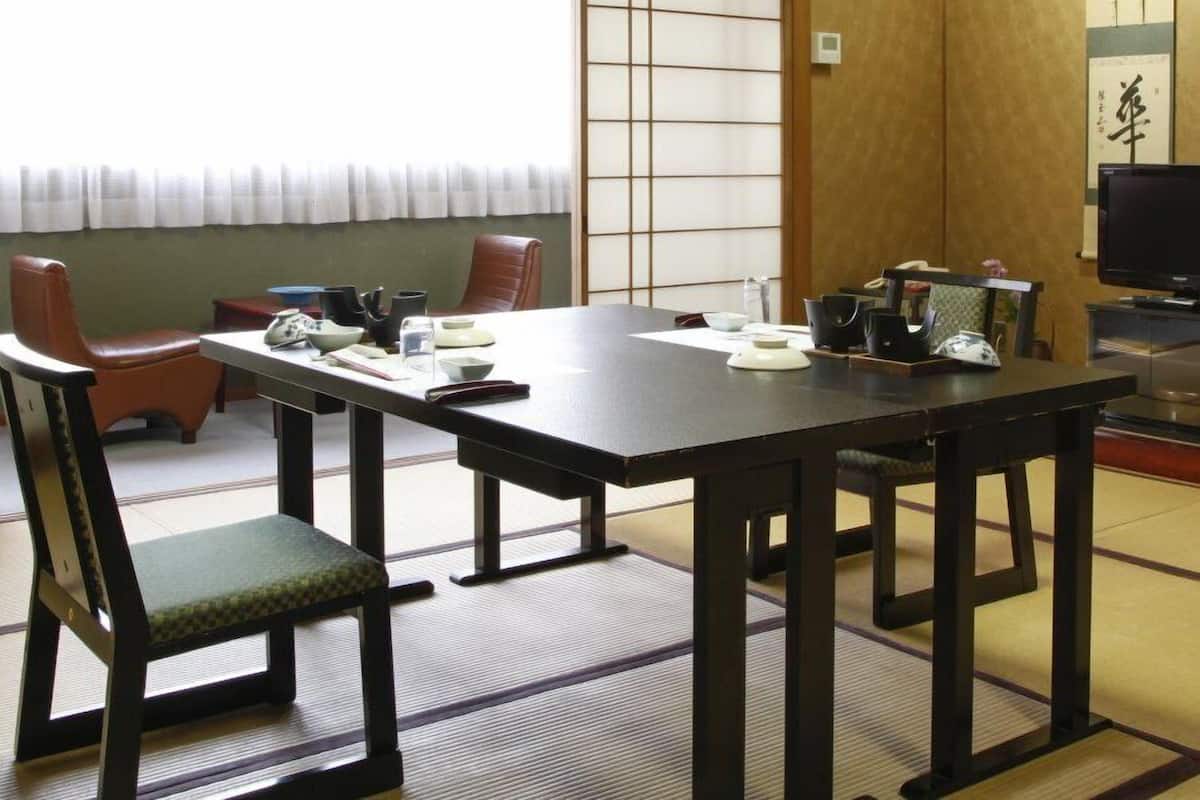 Une pièce de style japonais traditionnel, avec un sol recouvert de tatamis, une table basse et des paravents en papier de riz (shoji).