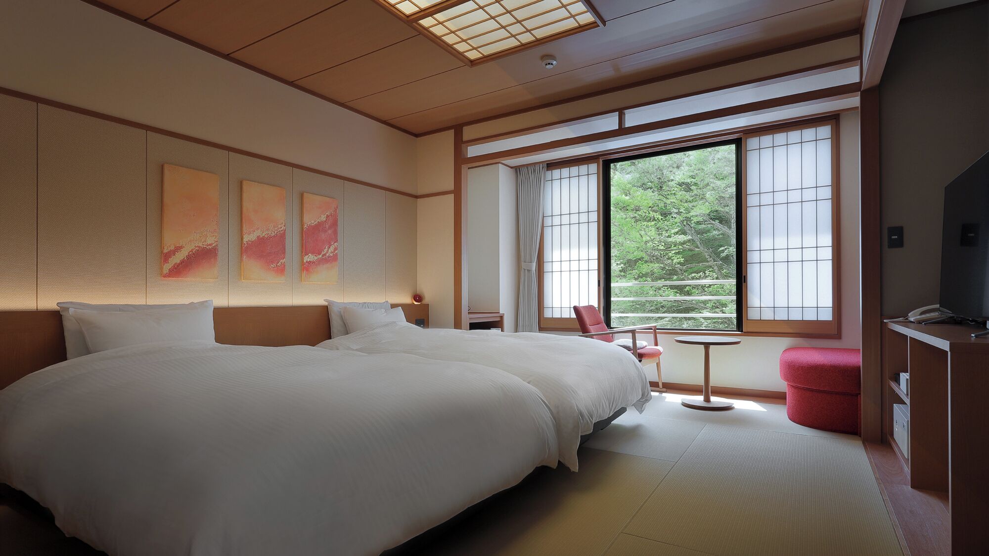 A hotel room with a large bed, a small table, a chair, and a TV.