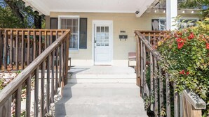 A front porch with a wooden railing, a white door, and a mailbox. - Downtown, Mins to Lakebottom Park-Our Midtown Nook (Columbus)