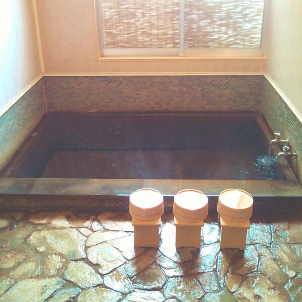 A stone-floored bathtub with a window above and three wooden stools in front. - Tenryuso (Otaki)