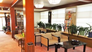 A library with bookshelves, seating, and potted plants. - Tenryuso (Otaki)