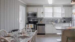 A modern kitchen with white cabinets, a microwave, stove, and dishwasher. - Historic Edgewood Home: Modern Charm, (Columbus)