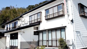 Un immeuble à plusieurs étages doté de grandes fenêtres, d’un balcon et de climatiseurs.