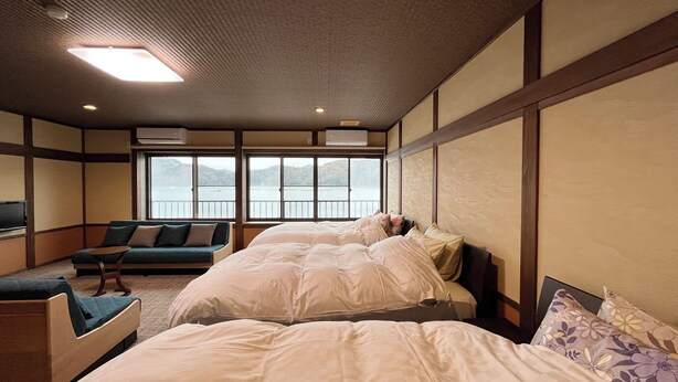 Une chambre avec deux lits, un canapé et une télévision.