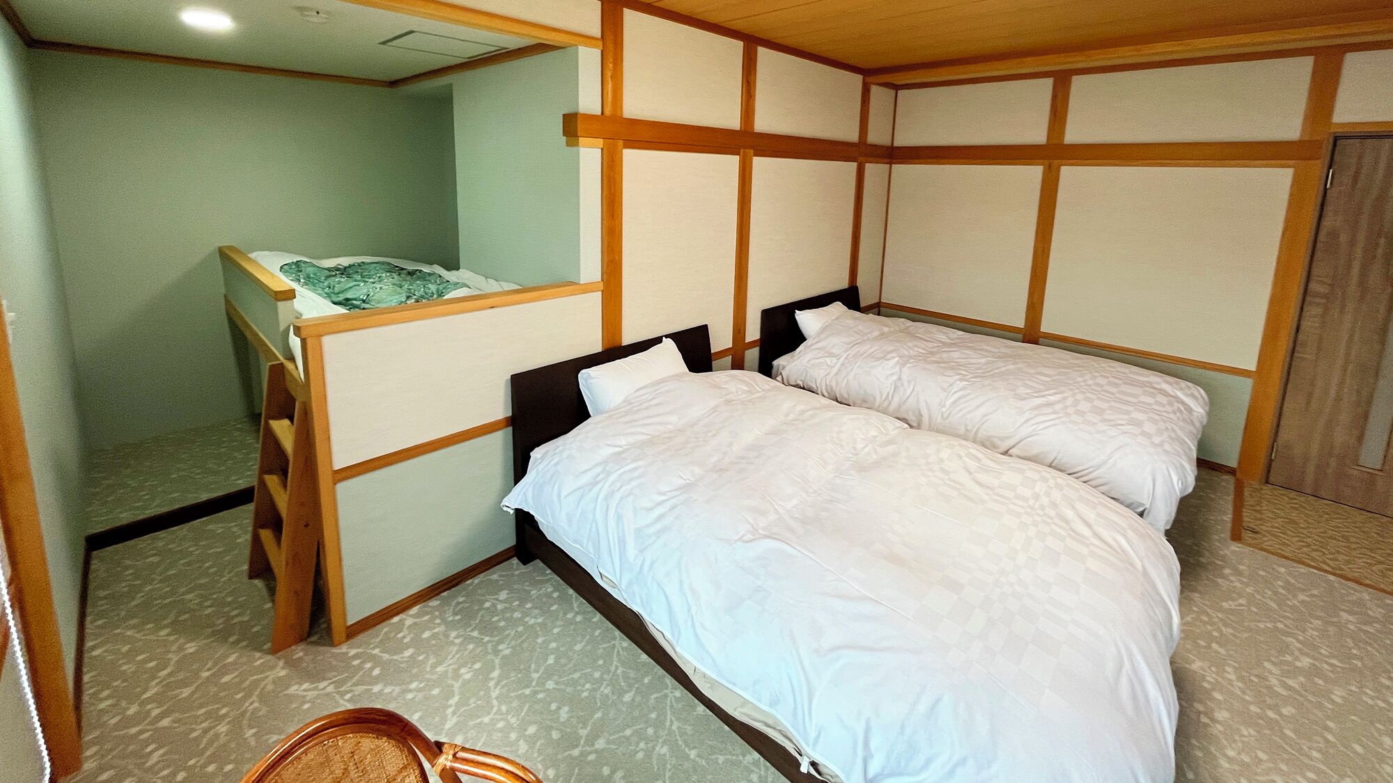 A room with a bunk bed, a desk, and a chair.