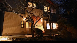 A two-story building with a brick facade, multiple windows, and a tree in front. - Mitaniya (Ito)
