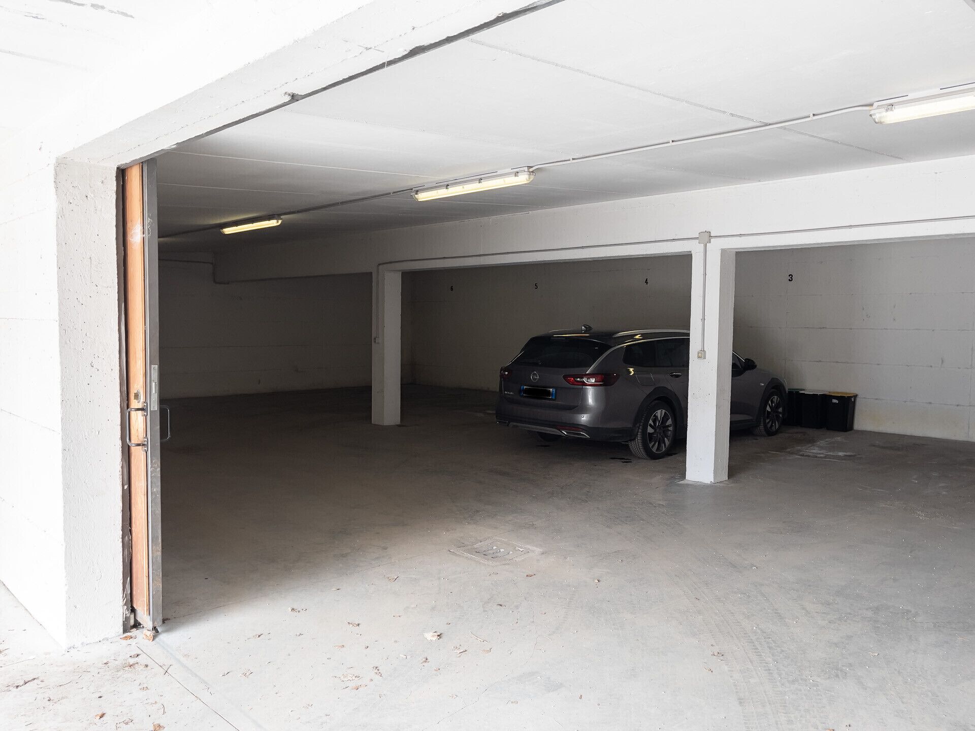 Un estacionamiento con un automóvil estacionado en un espacio.