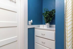 A bathroom with a white vanity, a blue wall, and a potted plant. - Historic Parkside Home w/ Fenced Yard, (Columbus)