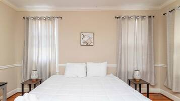 Une chambre d’hôtel avec un grand lit, deux tables de chevet avec des lampes et un tableau au mur.