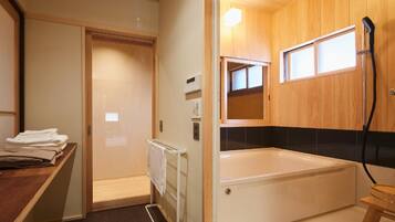 Un bagno con vasca, portasci, un armadietto in legno e una finestra.