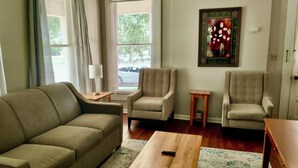 A living room with a sofa, two armchairs, a coffee table, and a small side table.