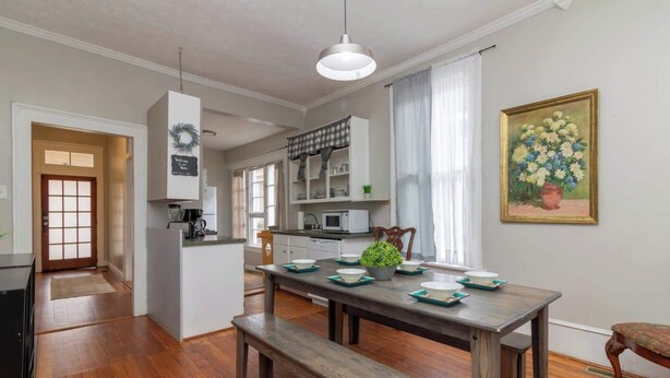 A dining area with a wooden table, benches, and a potted plant. - Large Downtown Home - The Sunny Southern Manse (Columbus)