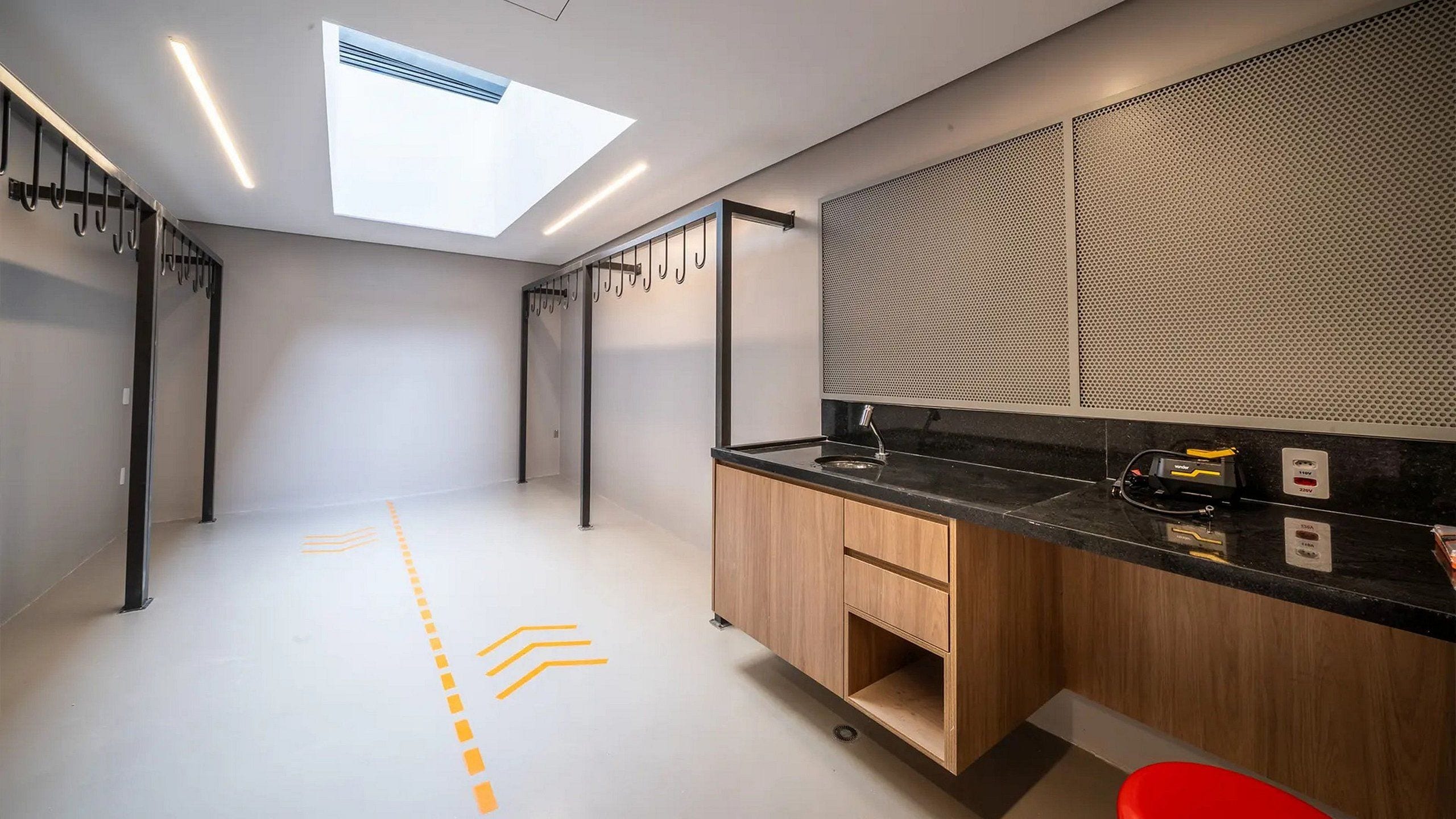 A modern kitchen with a skylight, wooden cabinets, and a black countertop.