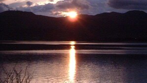A sunset over a body of water with mountains in the background. - Suikeisyoku No Shiteiseki Koya (Yurihama)