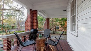 A covered porch with a brick chimney, outdoor seating, and a grill. - Midtown Main House w/ BBQ, Pets OK, Near Downtown (Columbus)